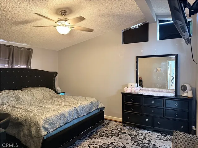 a bedroom with a bed and a mirror on the dresser