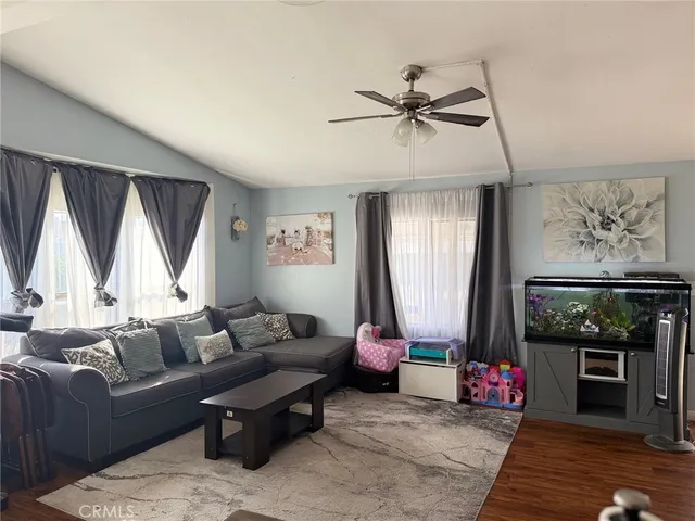 a living room with furniture a window and a flat screen tv