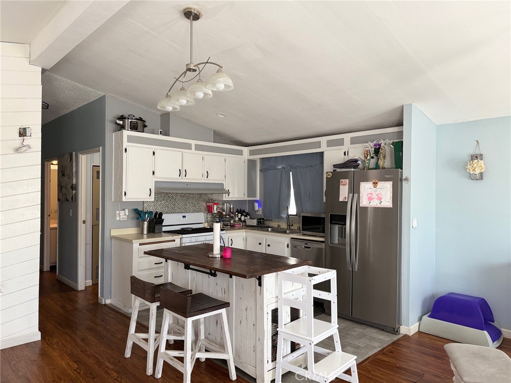 4080 Pedley Road, Unit 211 Jurupa Valley, CA 92509 - Photo 6 of 13 a kitchen with stainless steel appliances kitchen island granite countertop a refrigerator and a stove top oven