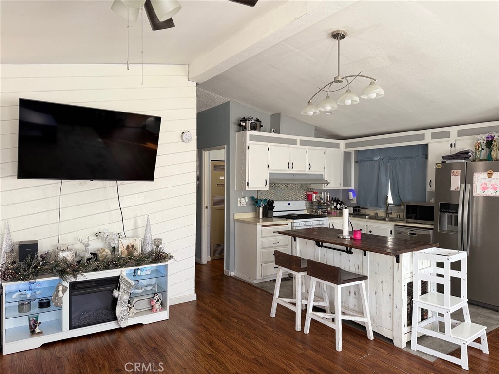 4080 Pedley Road, Unit 211 Jurupa Valley, CA 92509 - Photo 7 of 13 a kitchen with stainless steel appliances kitchen island granite countertop a stove and a wooden floor