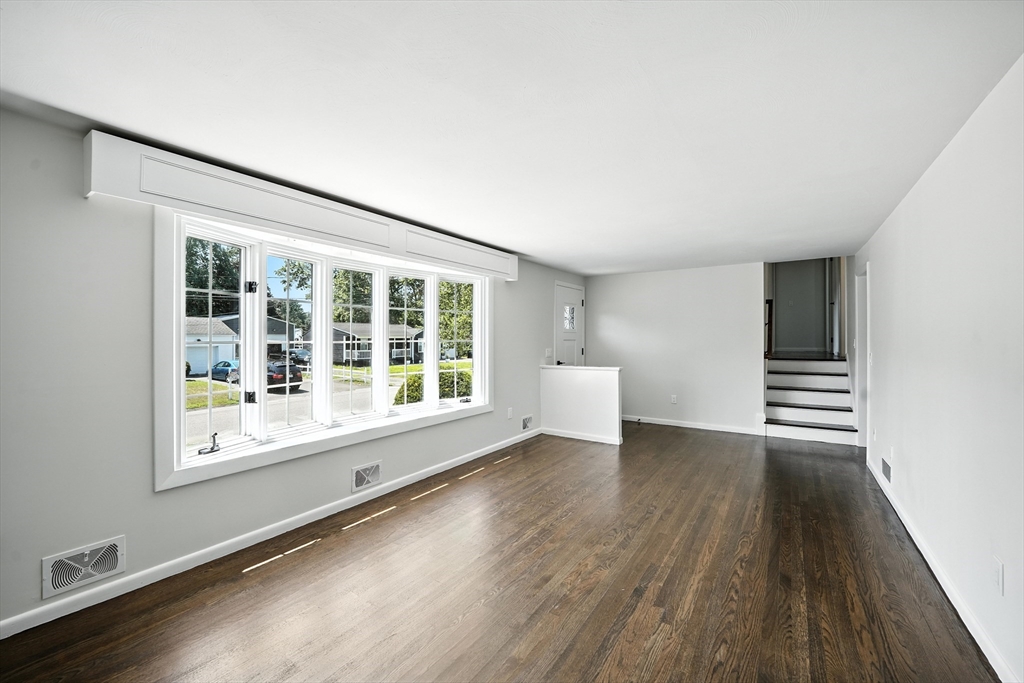76 Clydesdale Lane Springfield, MA 01129 - Photo 3 of 39 a view of an empty room with a window and wooden floor