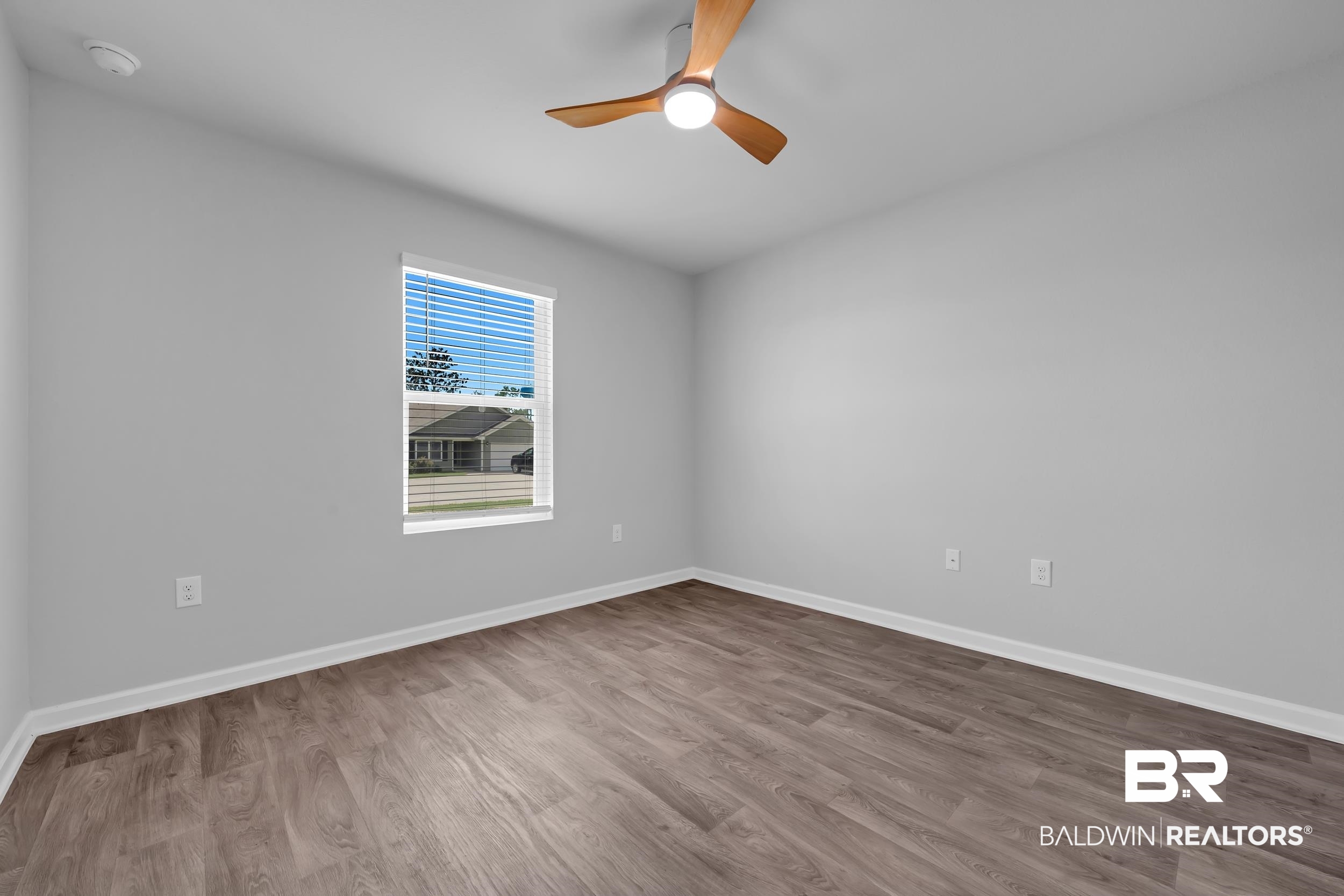 3070 Camino Real Loop Lillian, AL 36549 - Photo 30 of 46 Bright room with wood-finish flooring, light gray walls, and white baseboards
