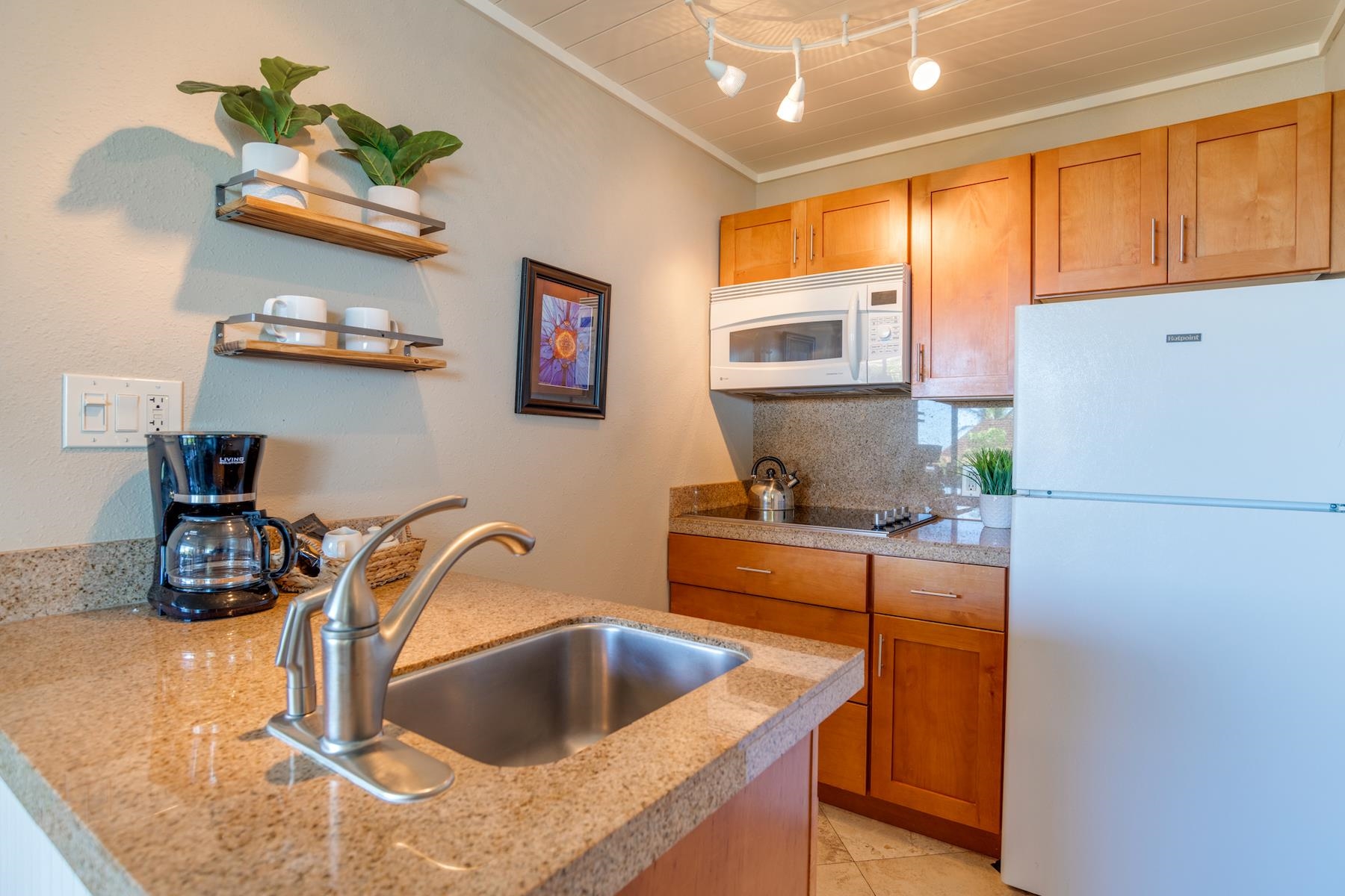 3601 Lower Honoapiilani Road, Unit 210 Lahaina, HI 96761 - Photo 6 of 25 a kitchen with stainless steel appliances granite countertop a sink a stove and a refrigerator