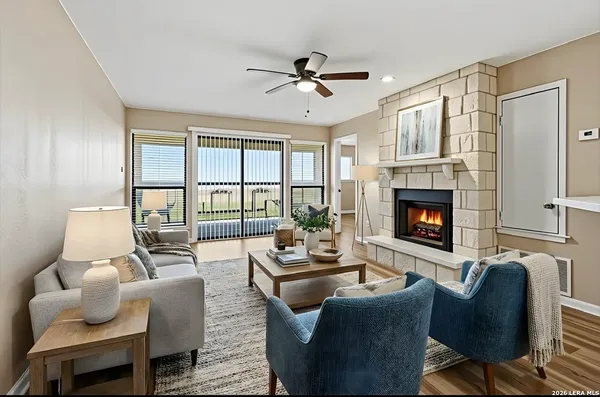 a living room with furniture fireplace and a large window