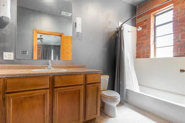 a bathroom with a granite countertop toilet sink and mirror
