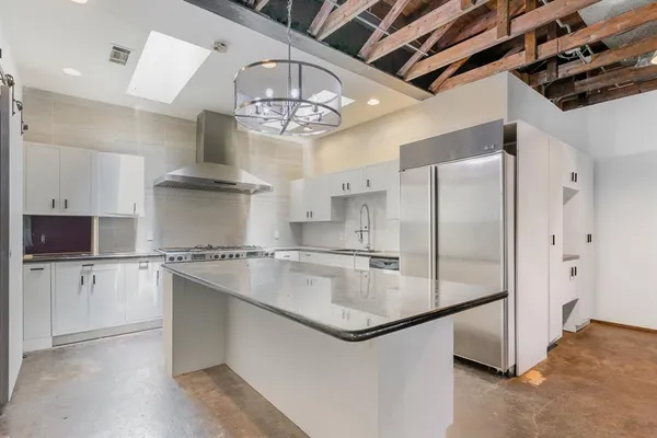 a kitchen with stainless steel appliances a refrigerator a sink and a stove