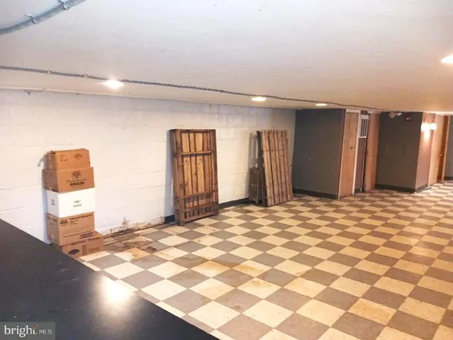 a view of a livingroom with wooden floor and a kitchen space