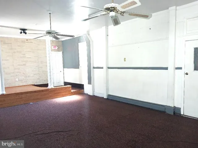 a view of a room with an empty space and a ceiling fan