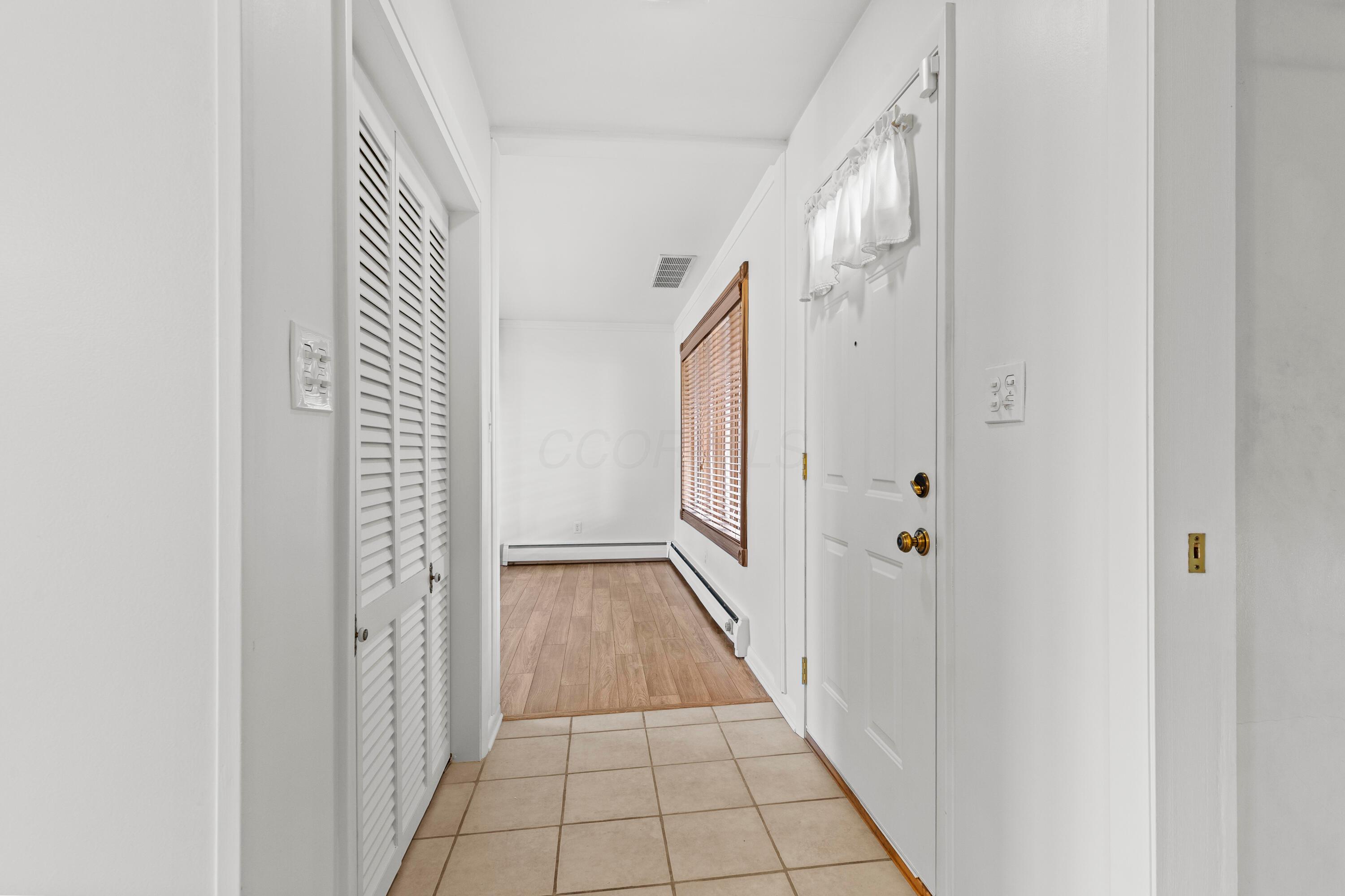 6982 Lee Road Westerville, OH 43081 - Photo 6 of 71 • Ceramic tile flooring • White painted walls • Ceiling light • Coat closet with bi-fold doors