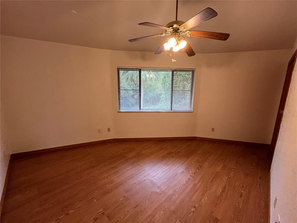 6560 Timberlane Road Lake Wales, FL 33898 - Photo 16 of 31 an empty room with wooden floor fan and windows