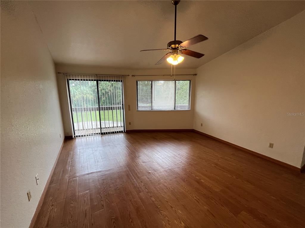 6560 Timberlane Road Lake Wales, FL 33898 - Photo 10 of 31 an empty room with wooden floor chandelier fan and windows