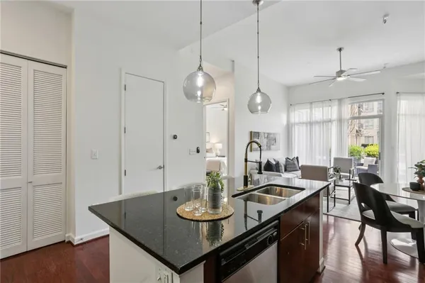 a kitchen with stainless steel appliances a dining table chairs stove and refrigerator