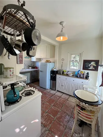 a kitchen with stainless steel appliances granite countertop a stove a sink a dining table and chairs