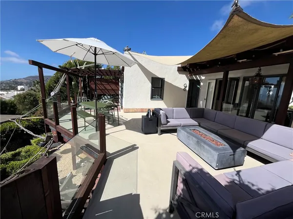 a view of a patio with table and chairs under an umbrella