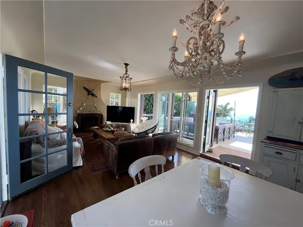 a living room with furniture a chandelier and a flat screen tv