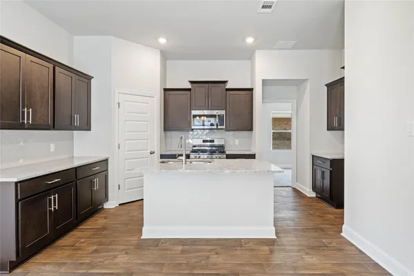 a kitchen with stainless steel appliances granite countertop a stove top oven and sink