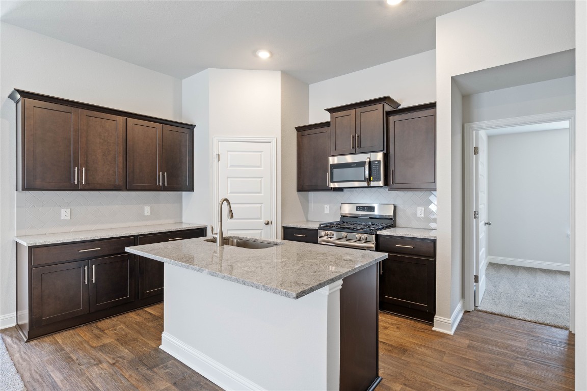 10641 Ellerston Road Cleveland, TX 77327 - Photo 13 of 34 a kitchen with granite countertop stainless steel appliances and wooden cabinets