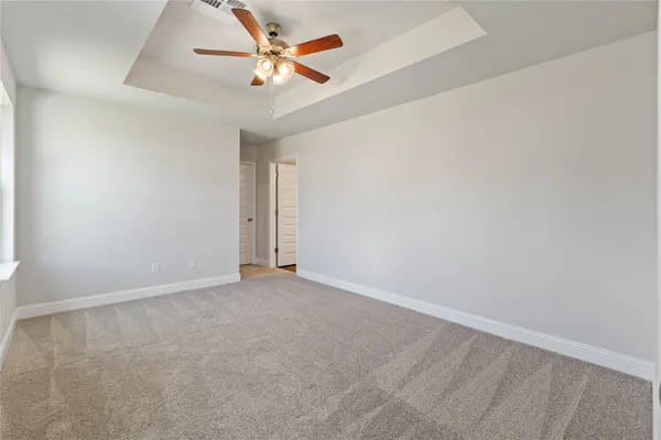 an empty room with a ceiling fan and a window