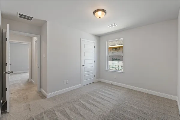 a view of an empty room with window and closet area