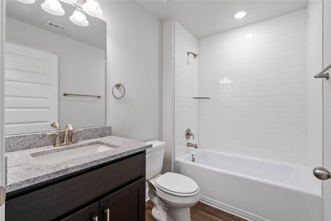 10641 Ellerston Road Cleveland, TX 77327 - Photo 28 of 34 a bathroom with a granite countertop bathtub sink vanity mirror and toilet