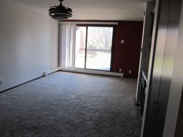 an empty room with windows and cabinet