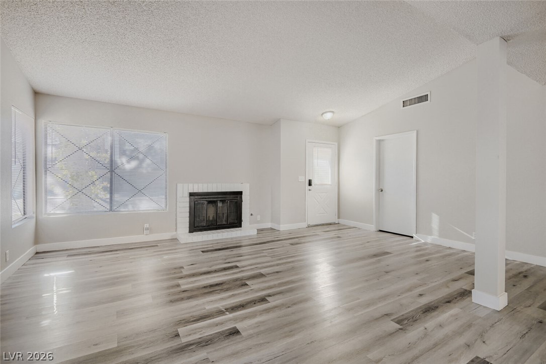 2343 Valleywood Road Henderson, NV 89014 - Photo 7 of 29 A generous living space featuring an inviting fireplace and easy-care laminate flooring.