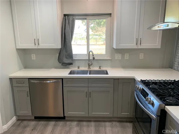 a kitchen with stainless steel appliances granite countertop a sink stove and cabinets
