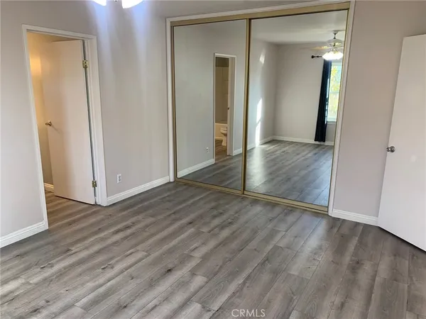 an empty room with wooden floor and mirror
