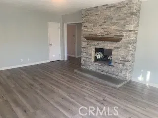 a view of empty room with wooden floor and fireplace