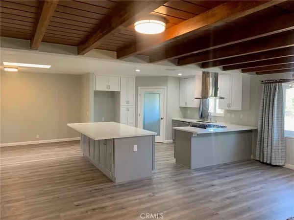 a kitchen with stainless steel appliances granite countertop a white cabinets and wooden floor