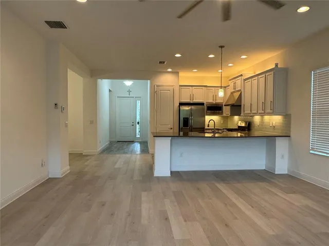 a view of kitchen with refrigerator and window