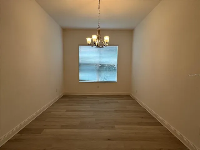 a view of wooden floor and a chandelier in a room