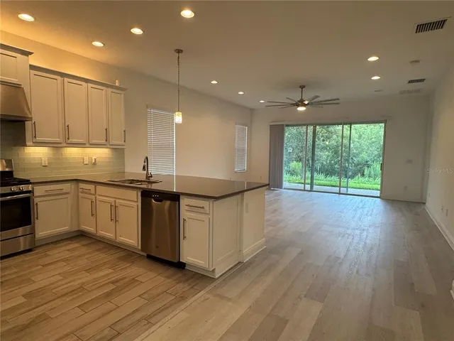a kitchen with stainless steel appliances granite countertop a stove a sink and a refrigerator
