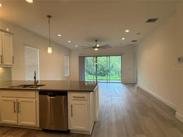 a kitchen with kitchen island granite countertop a sink a counter space and stainless steel appliances