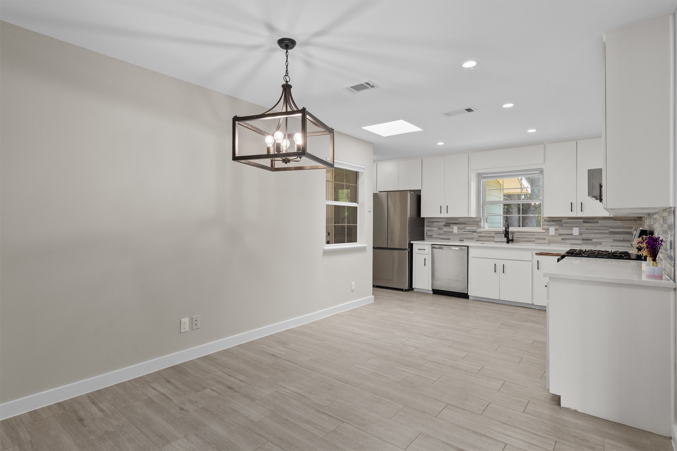 7707 Robalo Road Austin, TX 78757 - Photo 7 of 33 An open concept design seamlessly connects the dining area and kitchen, perfect for modern living.