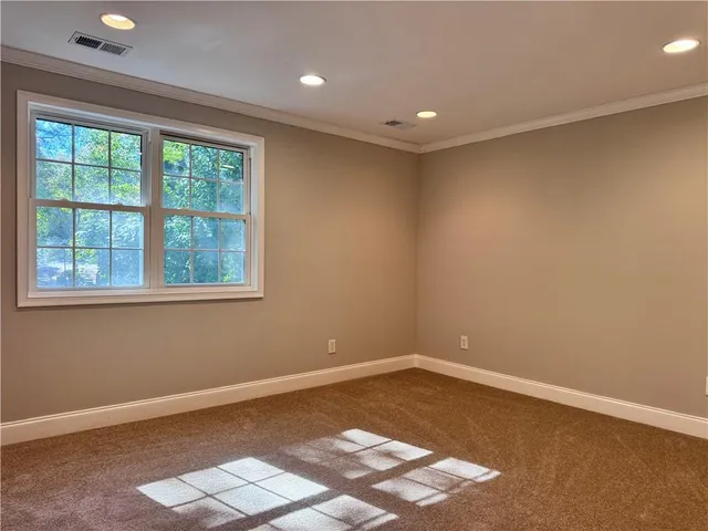 a view of a big room with wooden floor and windows