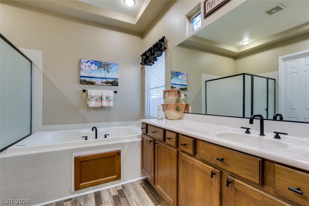 7524 Midnight Rambler Street Las Vegas, NV 89149 - Photo 39 of 51 A well-lit bathroom features a large soaking tub and a dual vanity with ample storage.