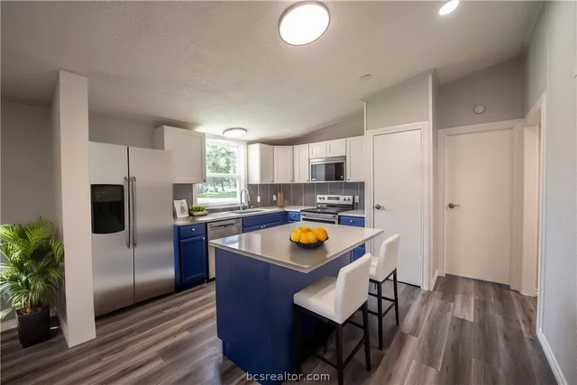 a kitchen with stainless steel appliances granite countertop a sink and a refrigerator