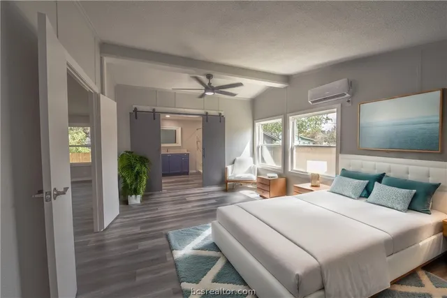 a bedroom with a large bed and a flat tv screen on dresser