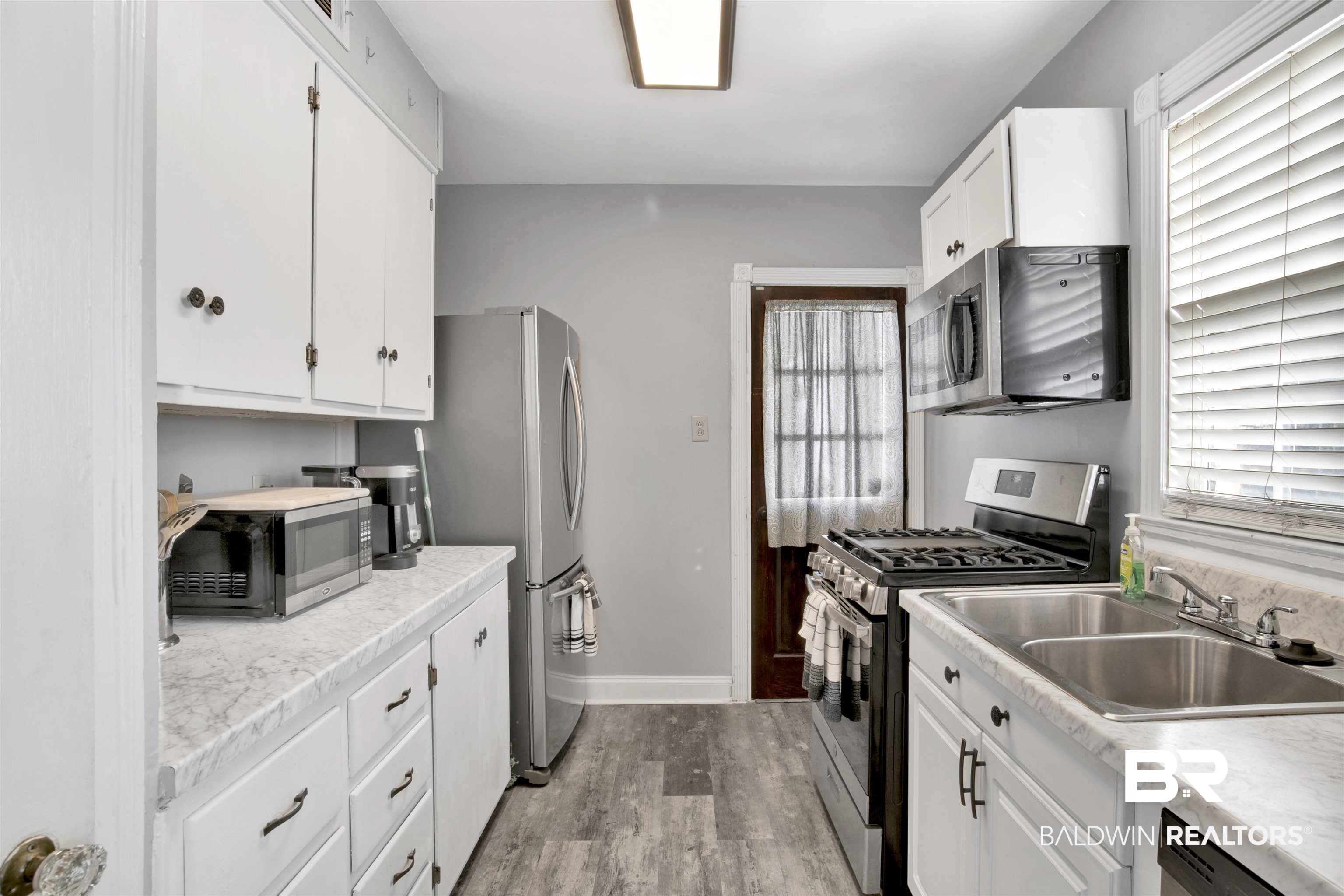 214 Upham Street, Unit 7A Mobile, AL 36607 - Photo 5 of 35 Kitchen with stainless steel appliances, white cabinetry, and light countertops