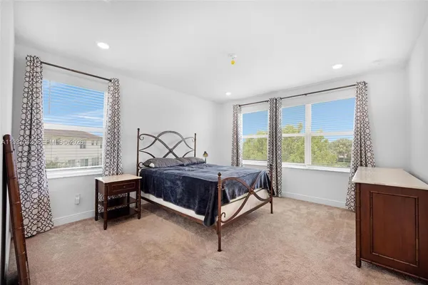 a bedroom with a bed and a large window