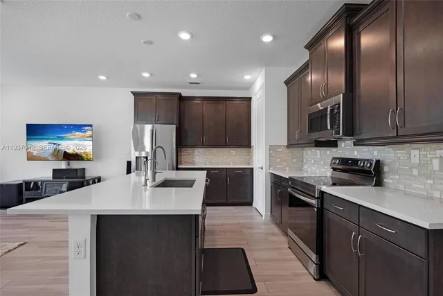 a kitchen with stainless steel appliances a sink stove and cabinets