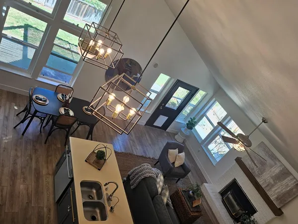 a living room with furniture a fireplace and a chandelier