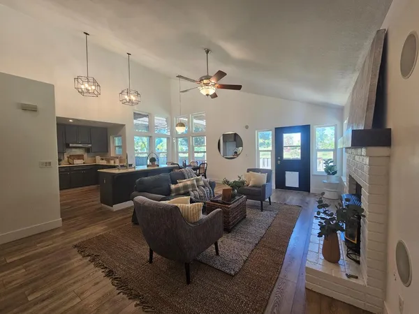 a living room with furniture kitchen view and a large window