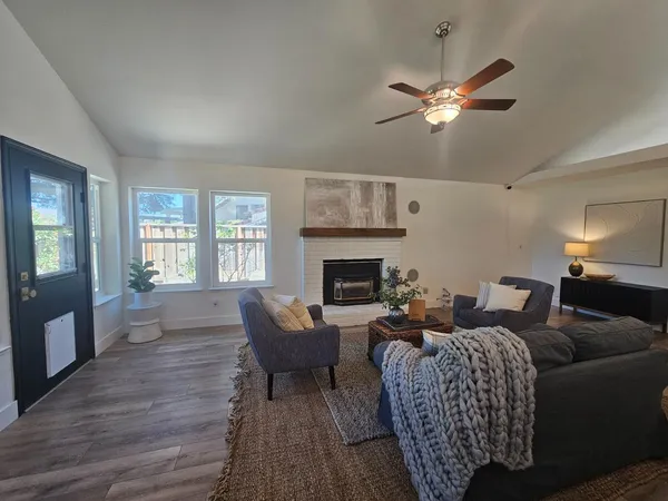 a living room with furniture a fireplace and a large window