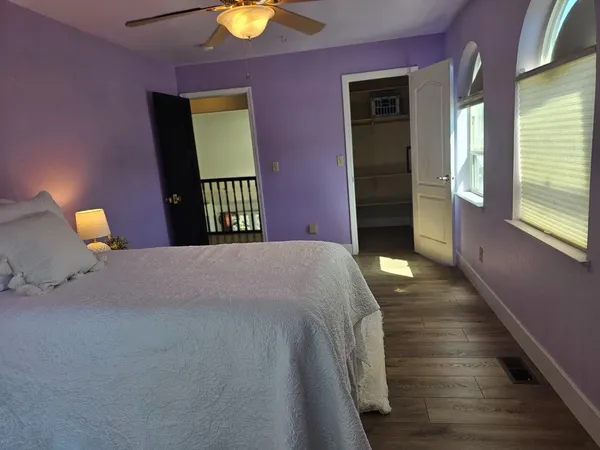 a bedroom with a bed and wooden floor