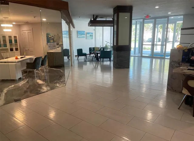 a dining hall with stainless steel appliances a dining table chairs and a rug