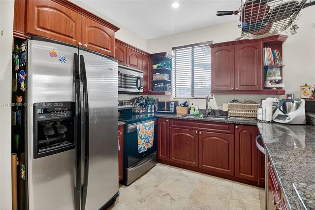 a kitchen with stainless steel appliances granite countertop a refrigerator and a sink