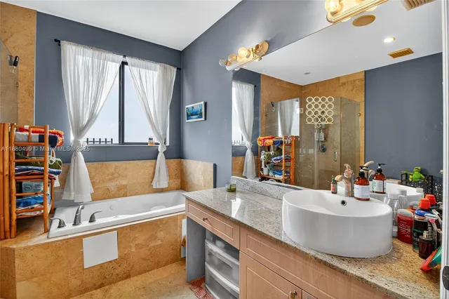 a bathroom with a tub sink and mirror