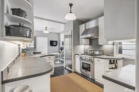 a kitchen with a stove and white cabinets